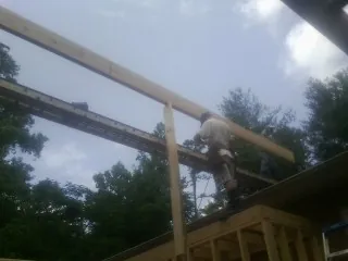 Carpenter setting a ridge beam over a new addition frame — Ice Dam Removal by Roofing Brothers in Powhattan
