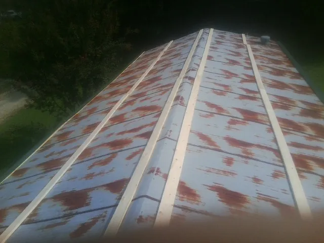 Rusted metal roof panels with new wood purlins before replacement in Powhattan