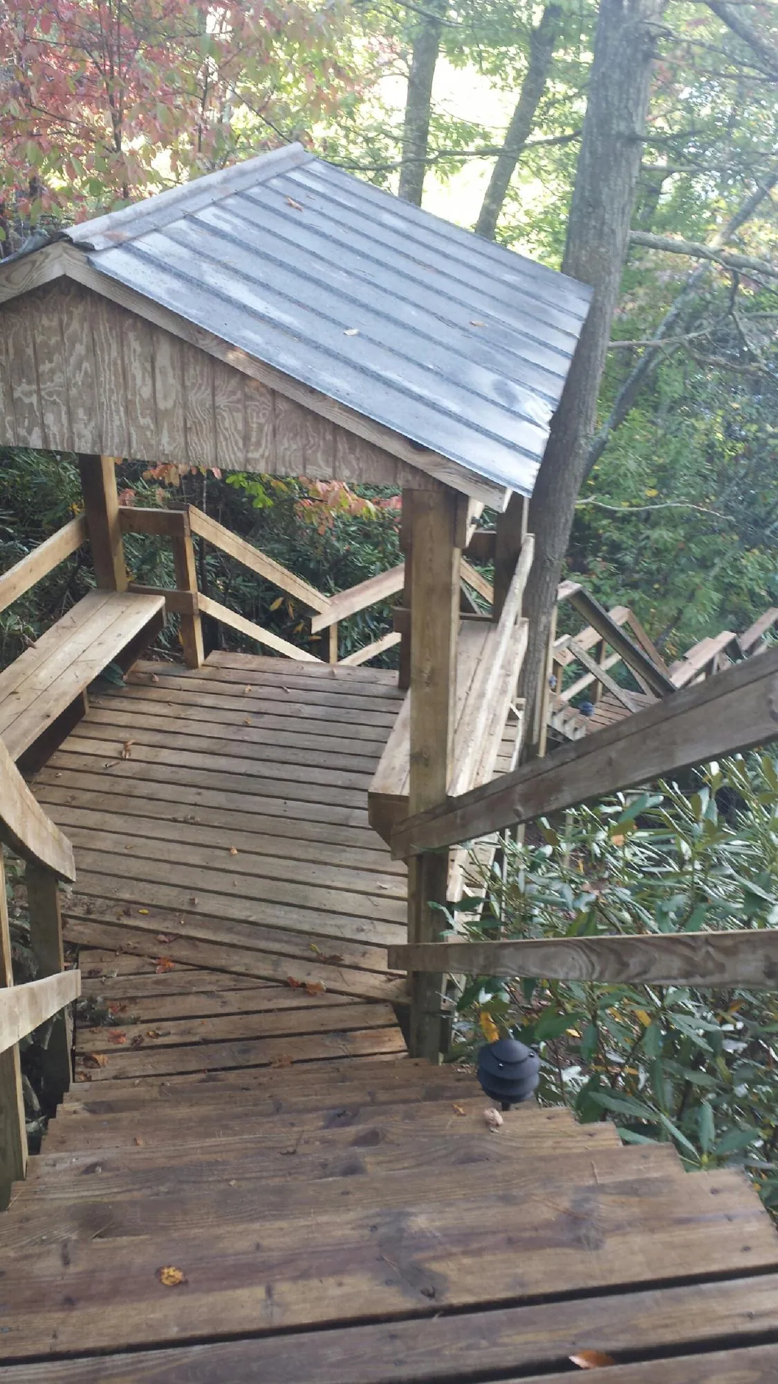 Metal roofed shelter over wooden steps on a wooded walkway — Skylight Repair & Installation work by our crew in Powhattan