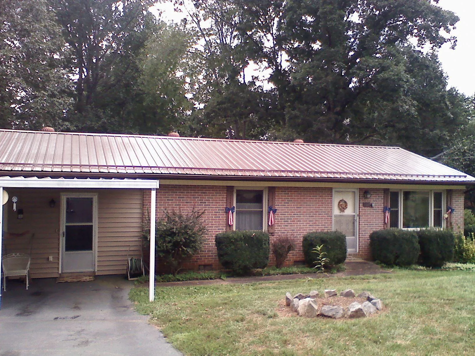 Bronze metal roof and carport on a brick ranch home — Roof Repair work by our crew in Powhattan